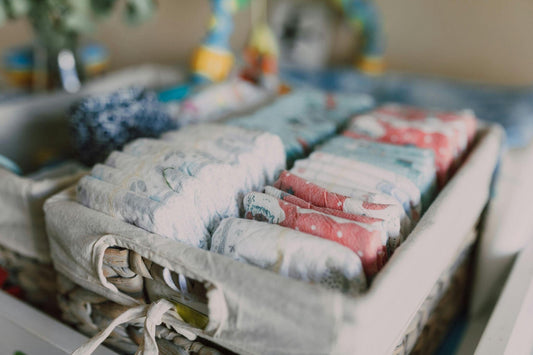 A curated newborn gift basket containing soft essentials, blankets, or milestone items.